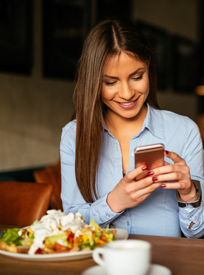 Woman at restaurant using her mobile phone
